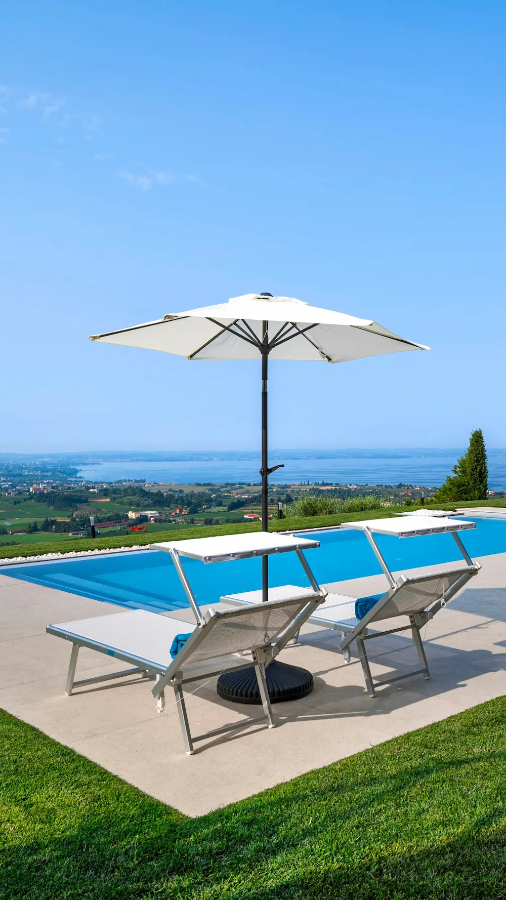 Dettaglio piscina panoramica con sdraio e ombrelloni, perfetta per rilassarsi ammirando il Lago di Garda.