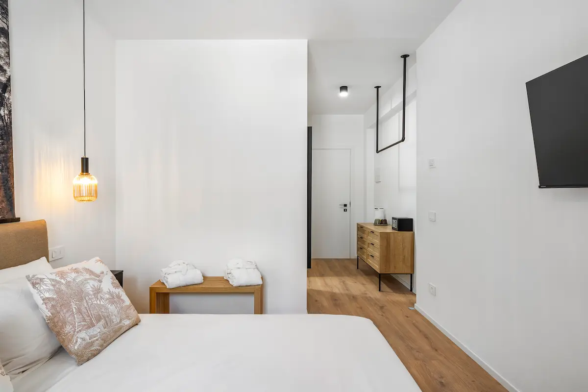 Ingresso camera con letto e interni eleganti, perfetta per una vacanza rilassante al The View Lake Garda.