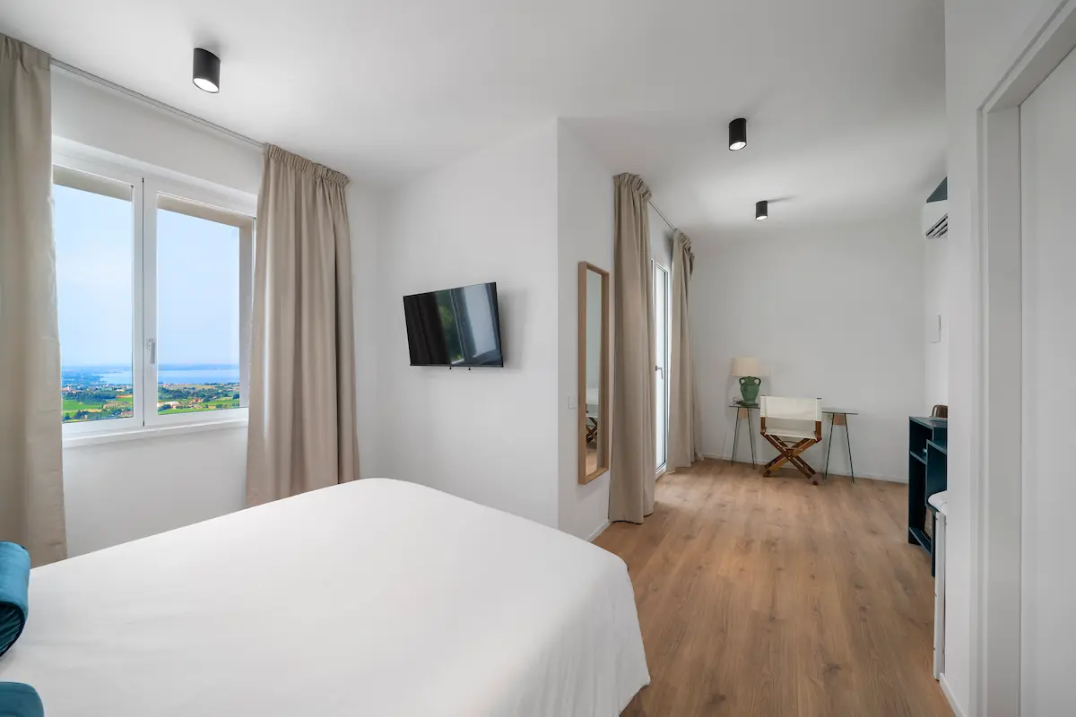 Camera luminosa con ampia finestra e dettagli curati, perfetta per svegliarsi con vista sul lago.